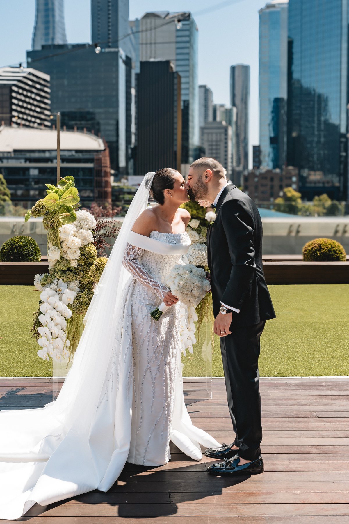 Crown Melbourne wedding — bride and groom at Crown Aviary with the city behind them, by C2 Films