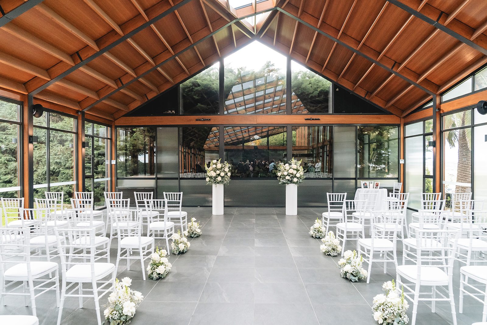 Marnong Estate wedding — the glass pavilion ceremony space with exposed timber trusses, by C2 Films
