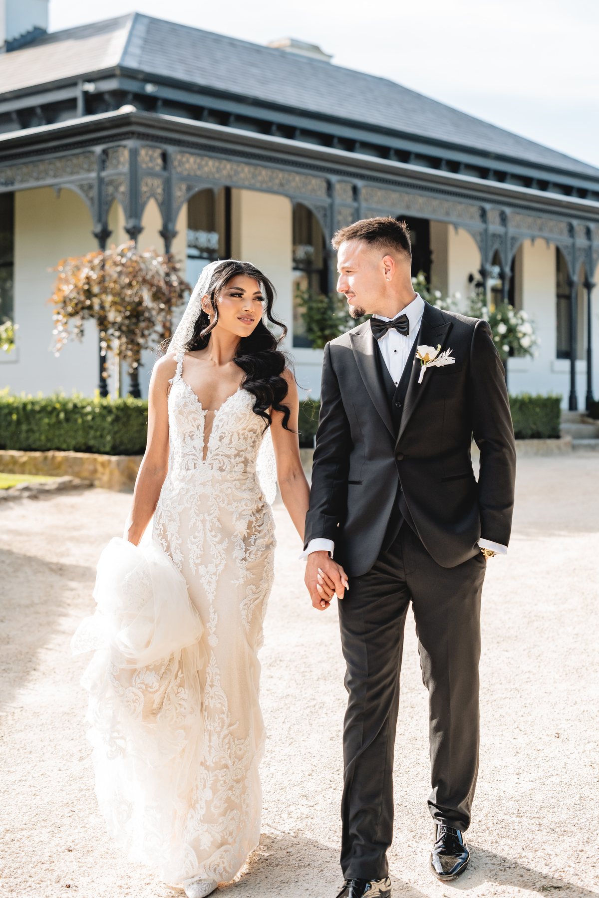 Marnong Estate wedding — bride and groom walking past the homestead verandah, by C2 Films