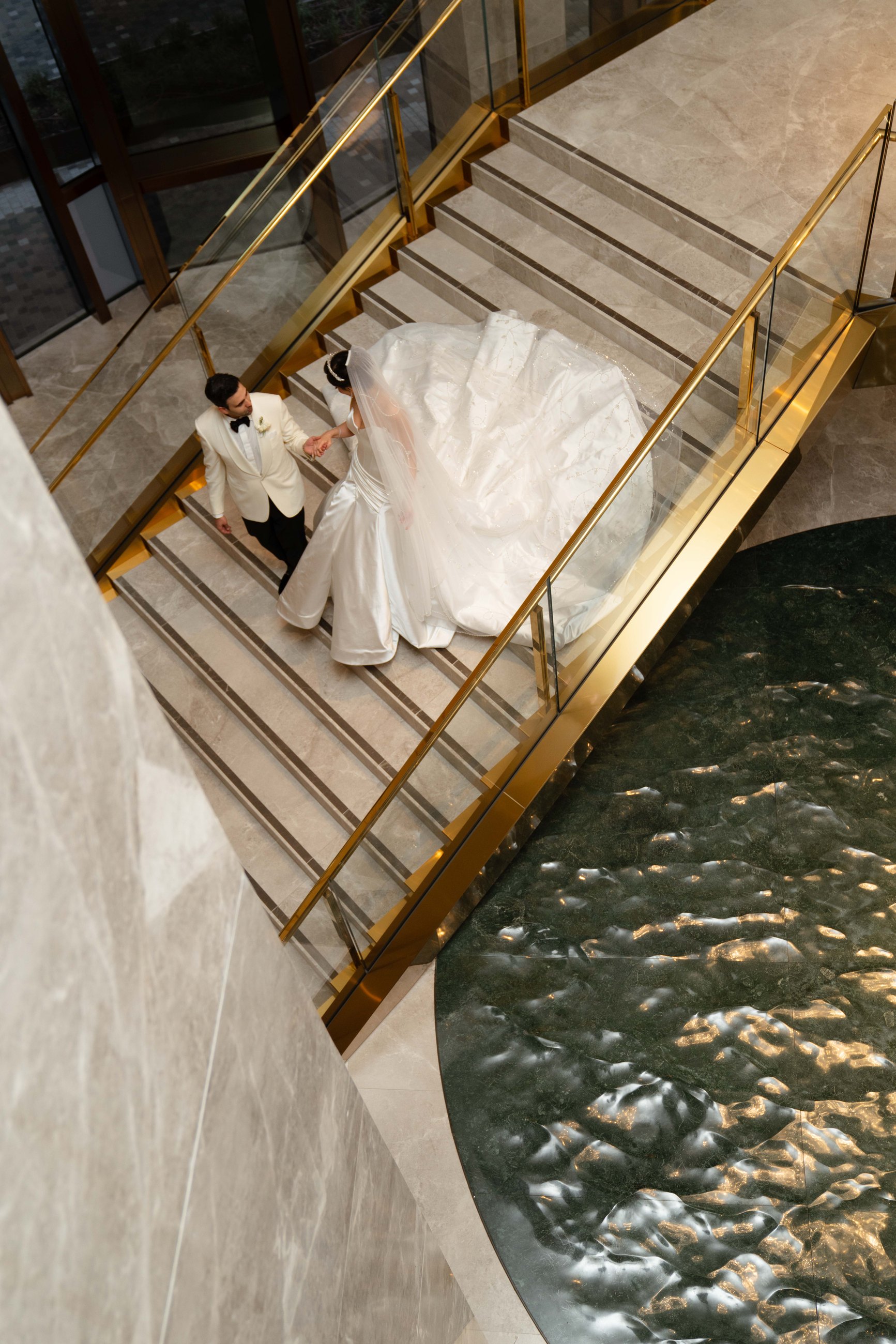 Ritz-Carlton Melbourne wedding — bride and groom on the marble staircase above the reflecting pool, photographed by C2 Films