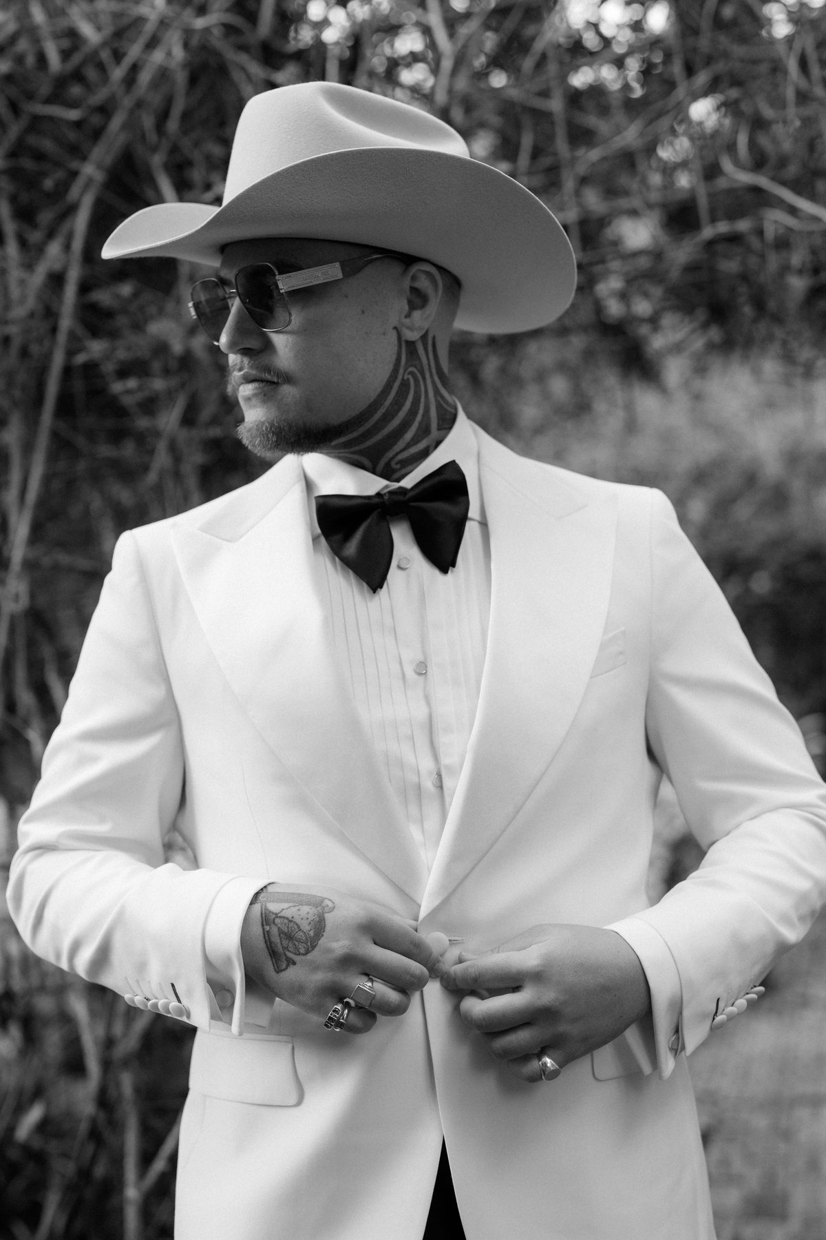 Kaleb setting his cowboy hat in the garden before the ceremony at Rosewood Estate, Beechmont QLD — wedding photography by C2 Films