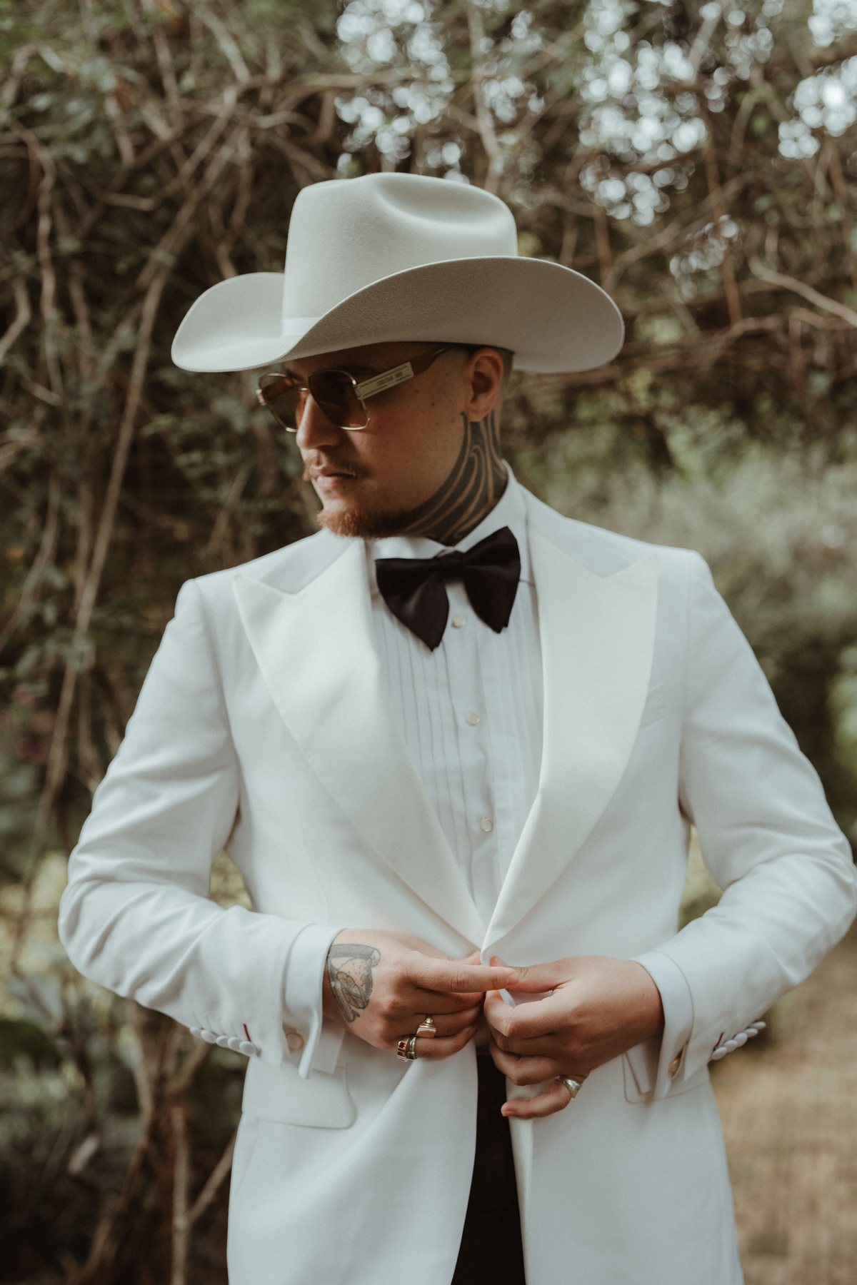 Kaleb in sunglasses and a white tuxedo on the morning of the wedding at Rosewood Estate, Beechmont QLD — wedding photography by C2 Films