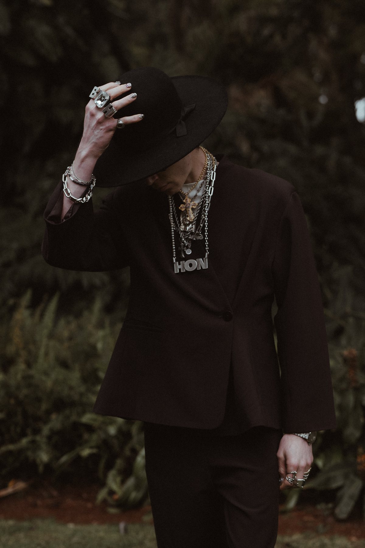 A groomsman lifting his wide-brimmed hat before the ceremony at Rosewood Estate, Beechmont QLD — wedding photography by C2 Films