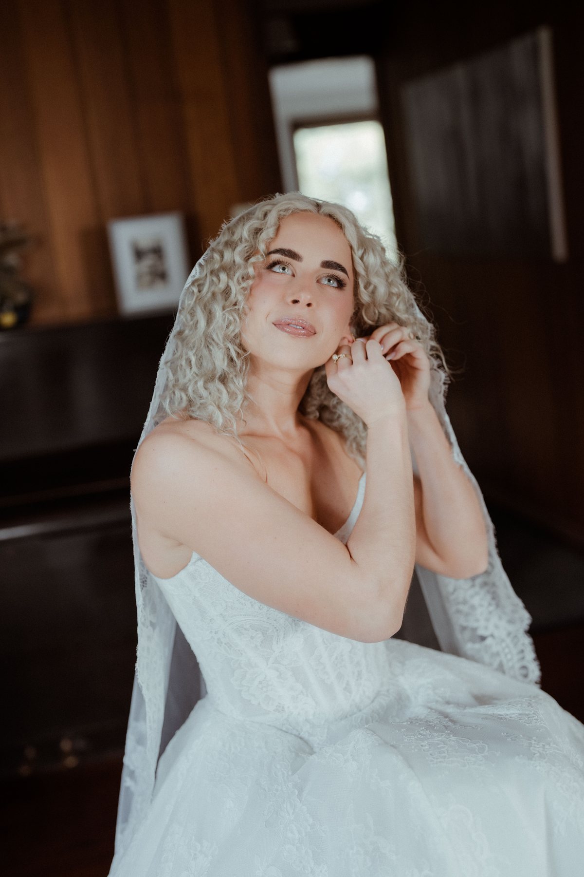 Monique touching her earring during bridal preparations at Rosewood Estate, Beechmont QLD — wedding photography by C2 Films