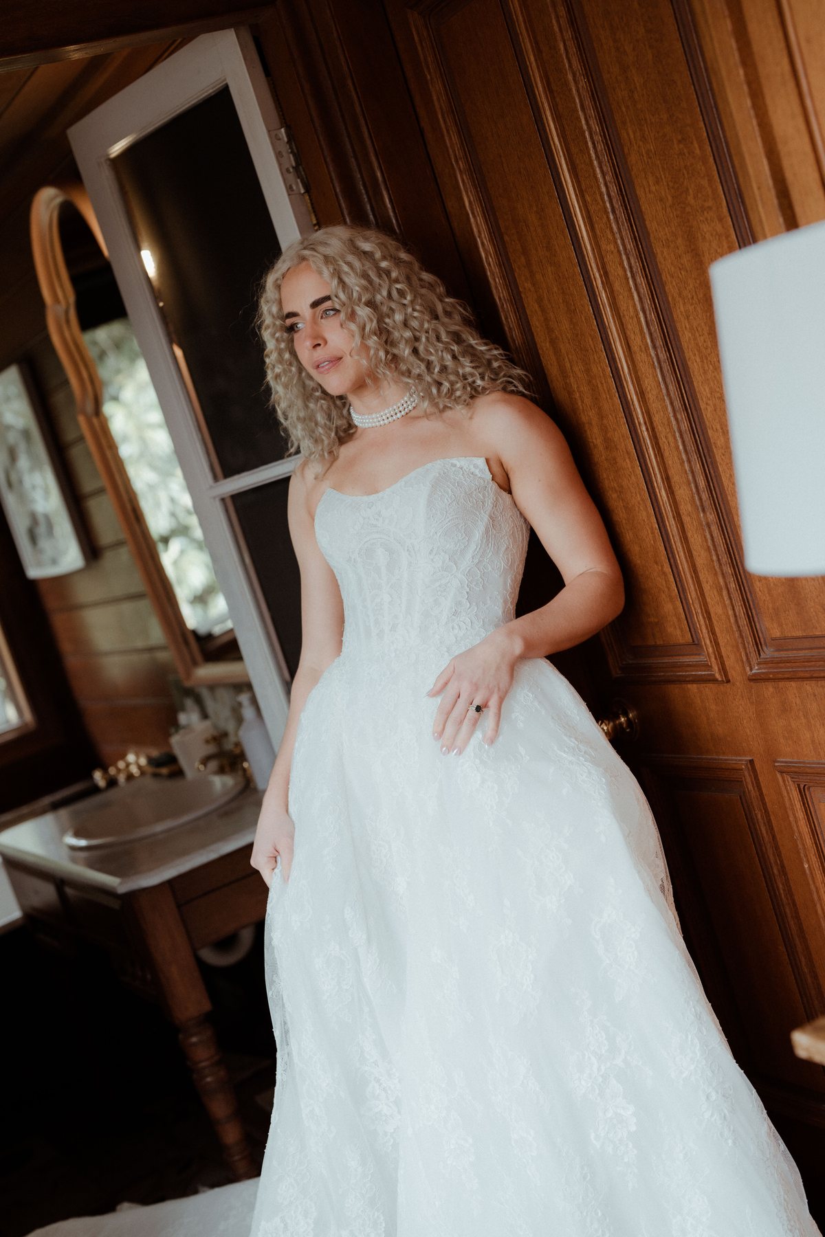 Monique framed in the doorway in her lace gown at Rosewood Estate, Beechmont QLD — wedding photography by C2 Films