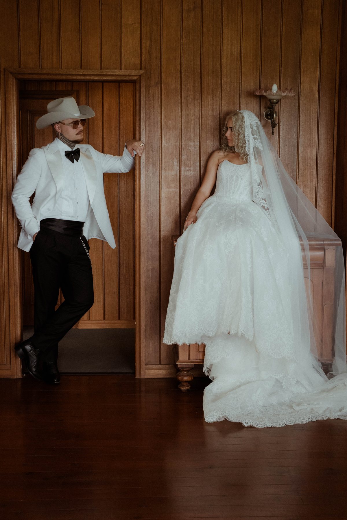Kaleb leaning in the doorway as Monique waits in her veil at Rosewood Estate, Beechmont QLD — wedding photography by C2 Films