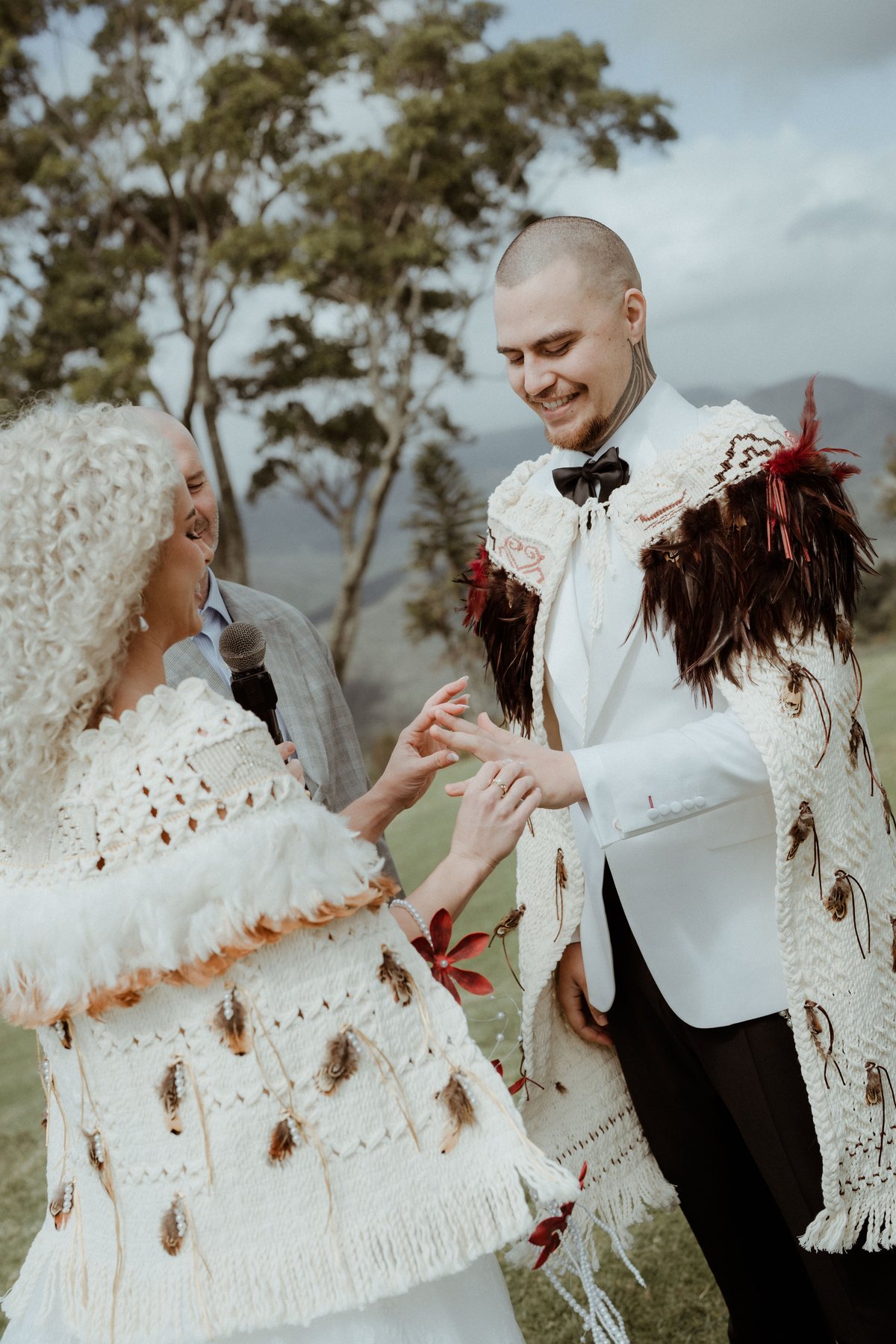 Exchanging rings in korowai during the ceremony at Rosewood Estate, Beechmont QLD — wedding photography by C2 Films