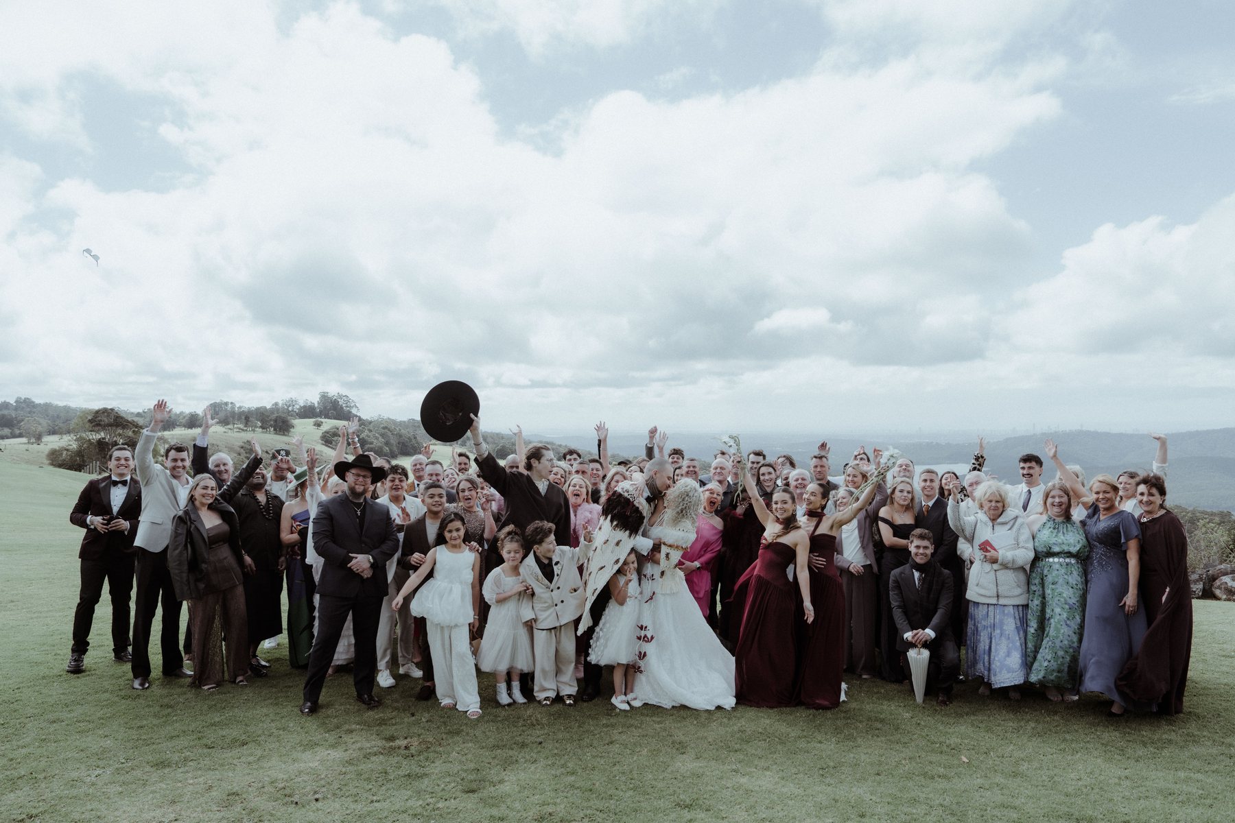 The full wedding party and guests on the hilltop at Rosewood Estate, Beechmont QLD — wedding photography by C2 Films