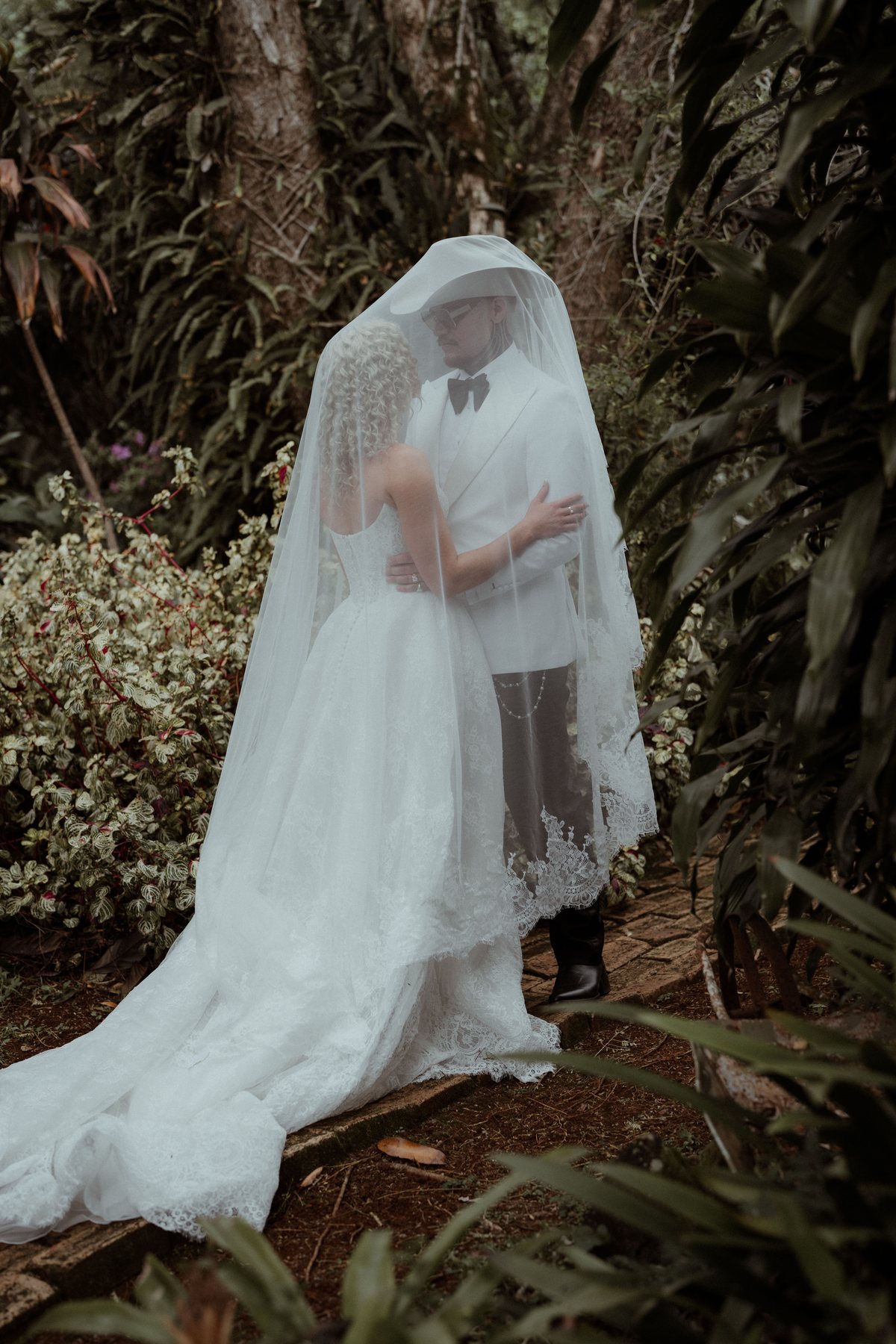Monique beneath her veil in the garden at Rosewood Estate, Beechmont QLD — wedding photography by C2 Films